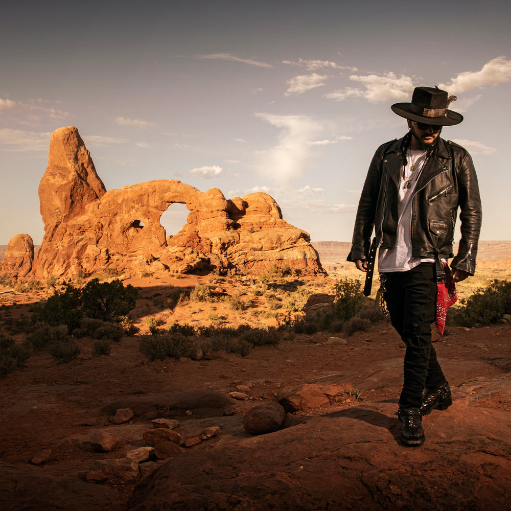 Singer Crucifix walking by the Turret Arch in Arches National Park Utah. SaintCruce