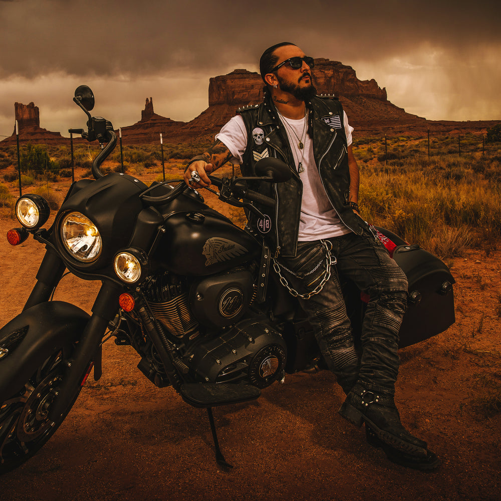 Singer Crucifix sits on an Indian Motorcycle between the Buttes of Monument Valley Utah. SaintCruce